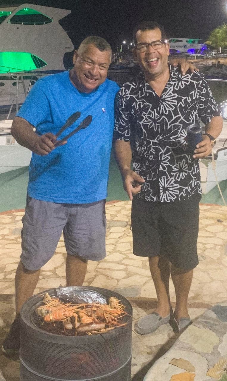 Dario Lopez with a friend grilling fresh lobster at the Bayahibe marina